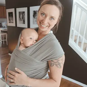 mother and son in grey boba baby wrap mom smiling at camera son resting head on her chest