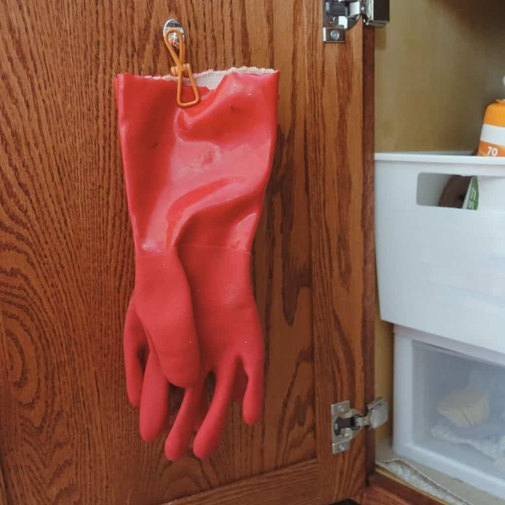 kitchen cleaning glove hanging on hook behind cabinet door