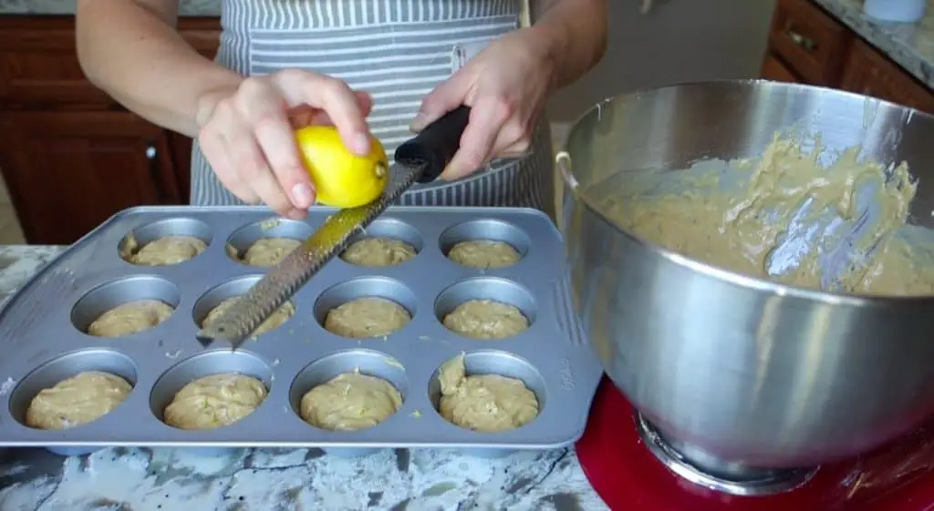 zesting lemon on top of lemon and lavender sourdough discard muffins