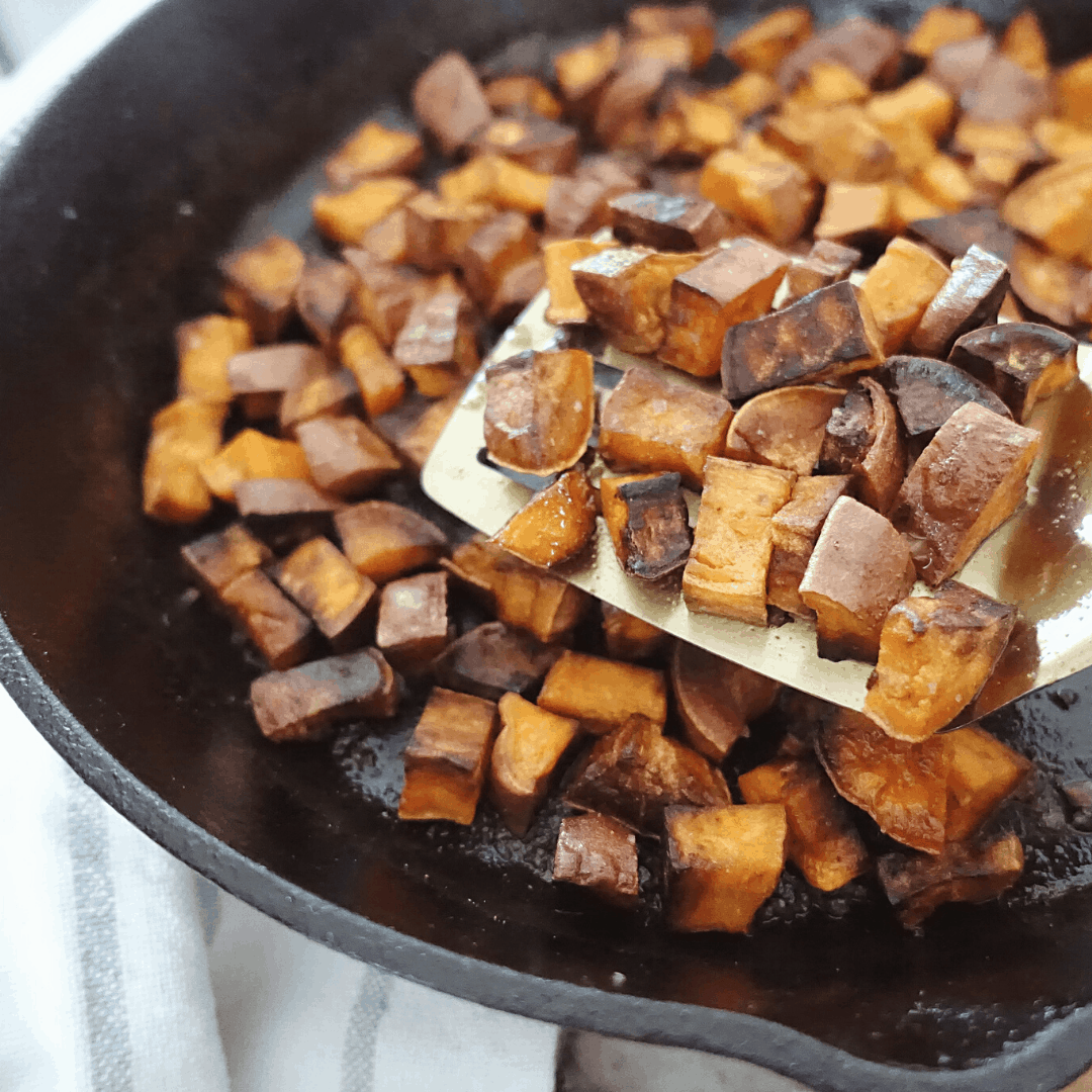 crispy sauteed sweet potatoes in a cast iron skillet
