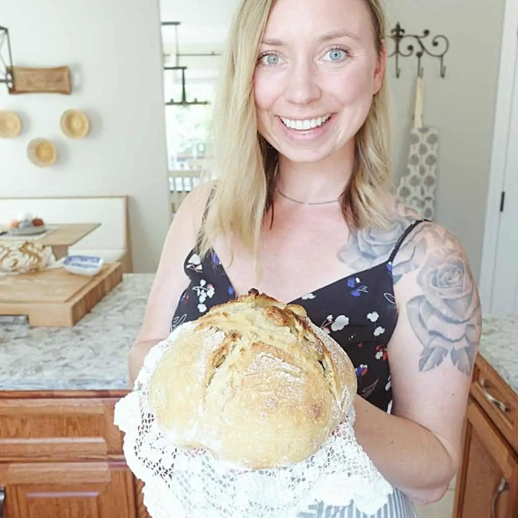 kyrie with healthfully rooted home holding roasted garlic sourdough bread on top of a doily