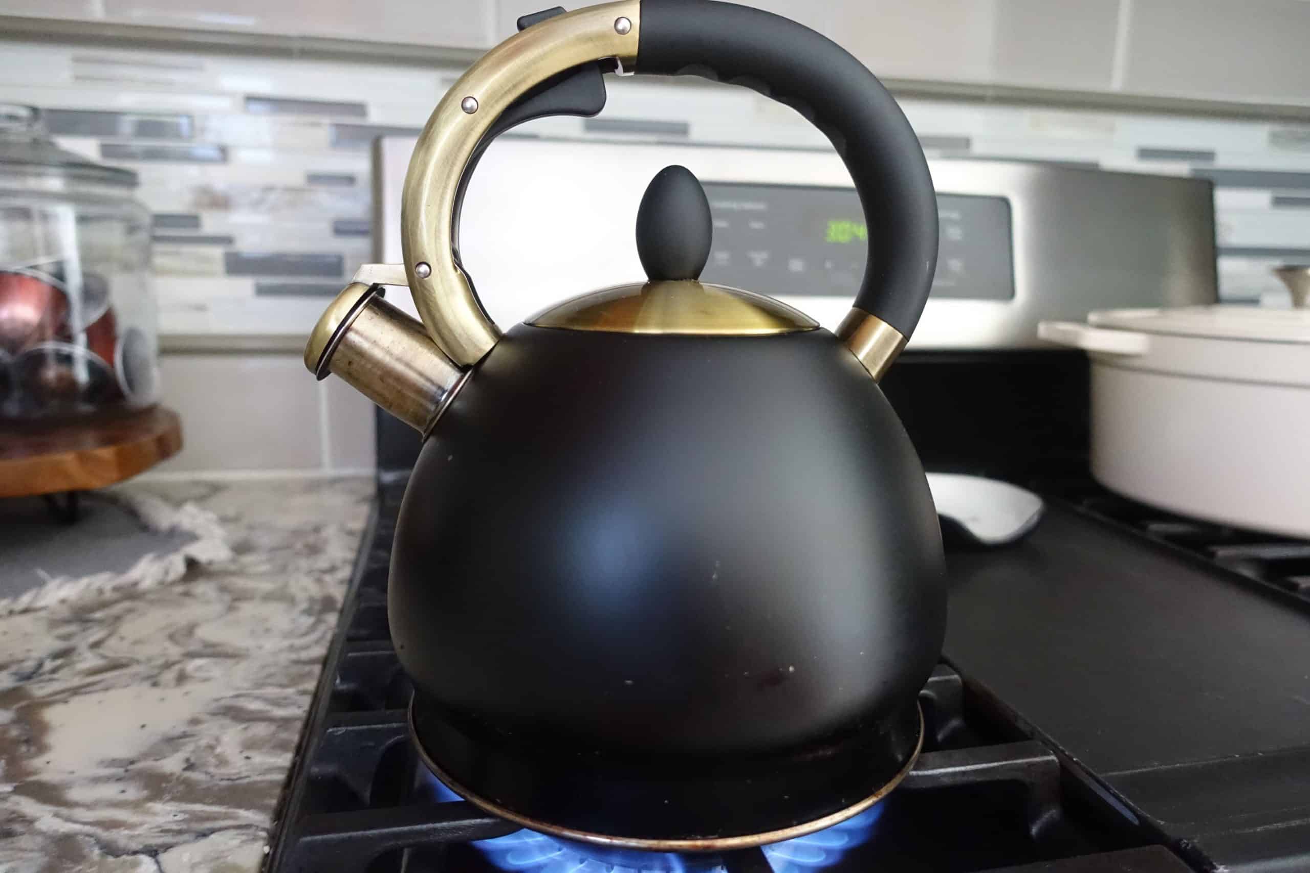 matte black tea kettle on gas stove with burner on