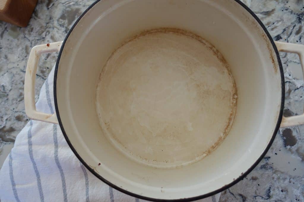 inside of a dirty white enameled dutch oven