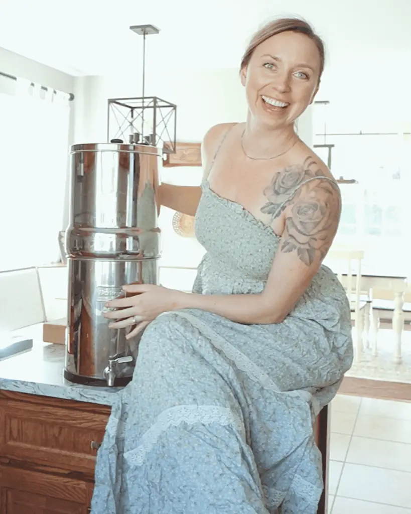 kyrie with healthfully rooted home showing off her berkey water filter so she can live a clean lifestyle by filtering her water