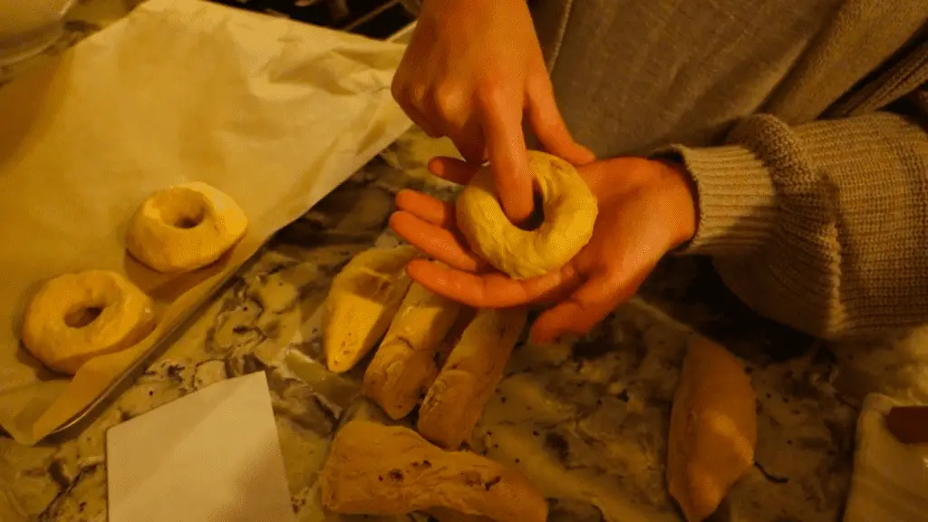 shaping sourdough bagel dough with fingers 