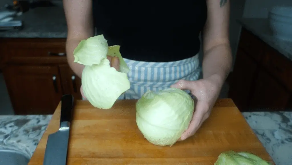 peeling the outer cabbage leaves off cabbage head
