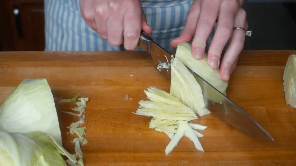 slicing the cabbage into shreds to use for curry kraut