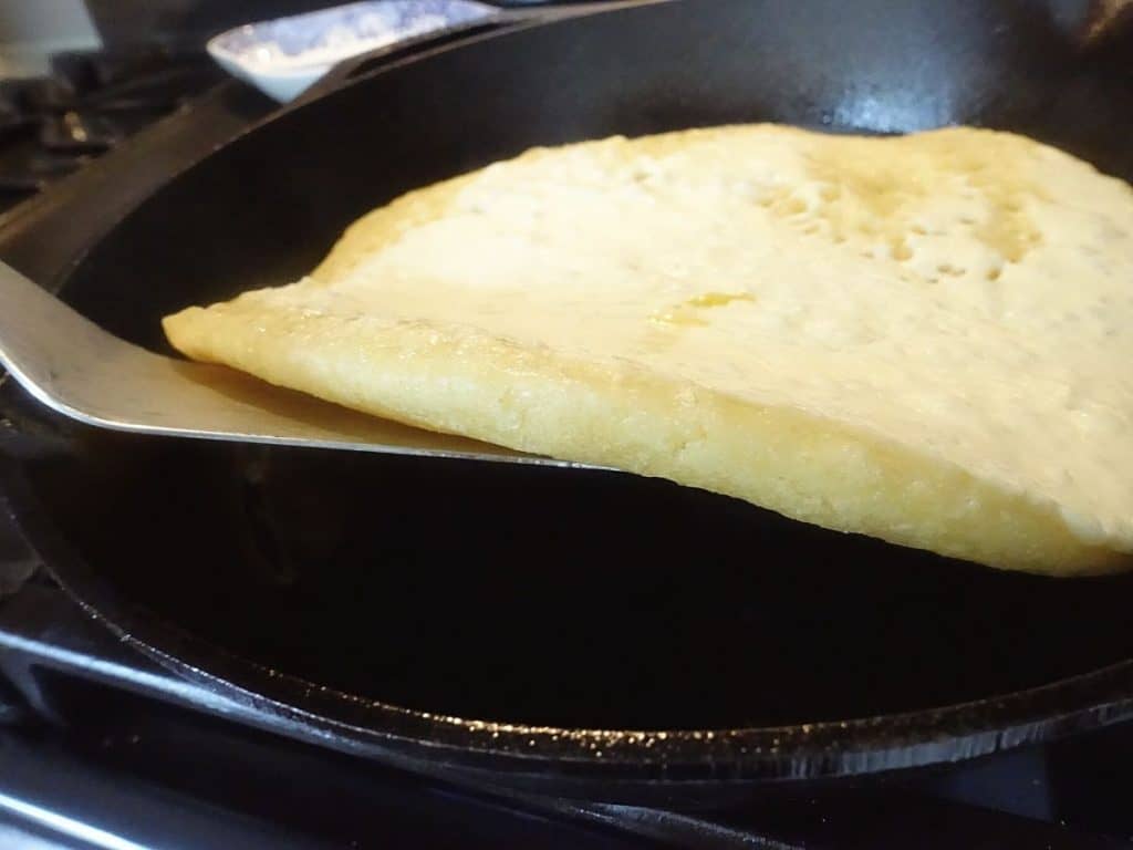 using a spatula to lift up the sourdough discard flatbread 