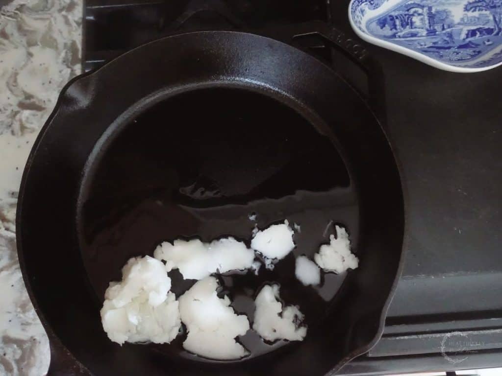 coconut oil on a cast iron skillet next to a blue and white tray