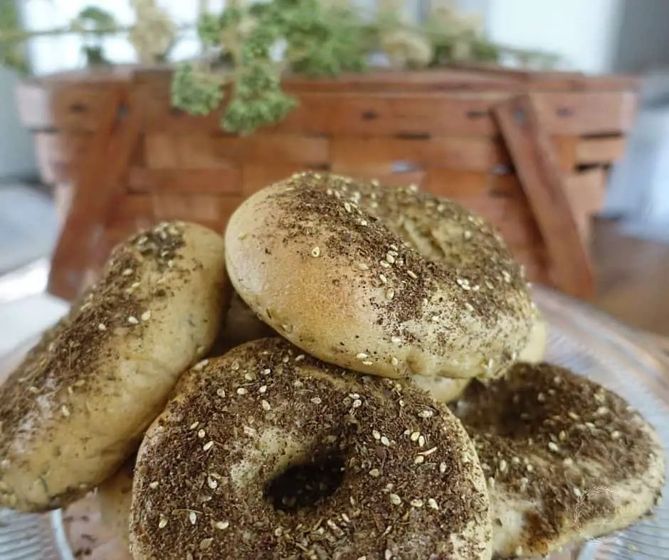 homemade zaatar bagels stacked on top of eachother with a basket in the background