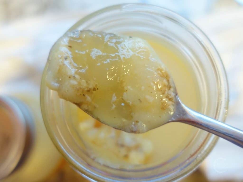 gelatinous chicken collagen soup on a spoon overtop a mason jar