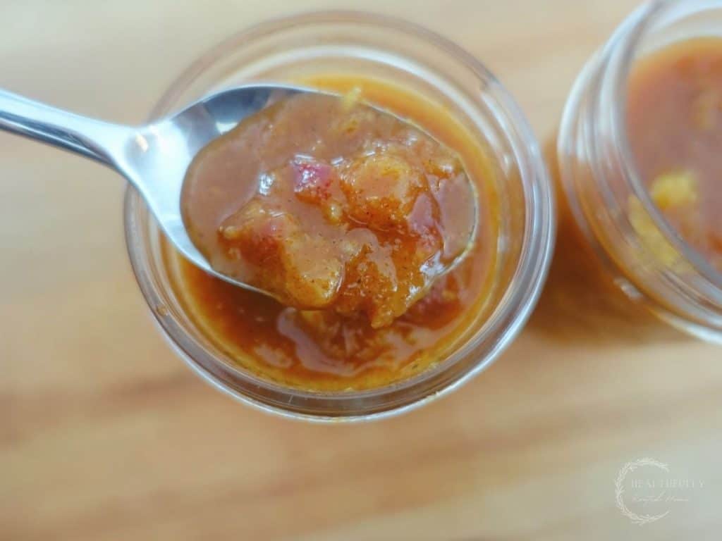 fermented mango chutney in a mason jar with a spoon