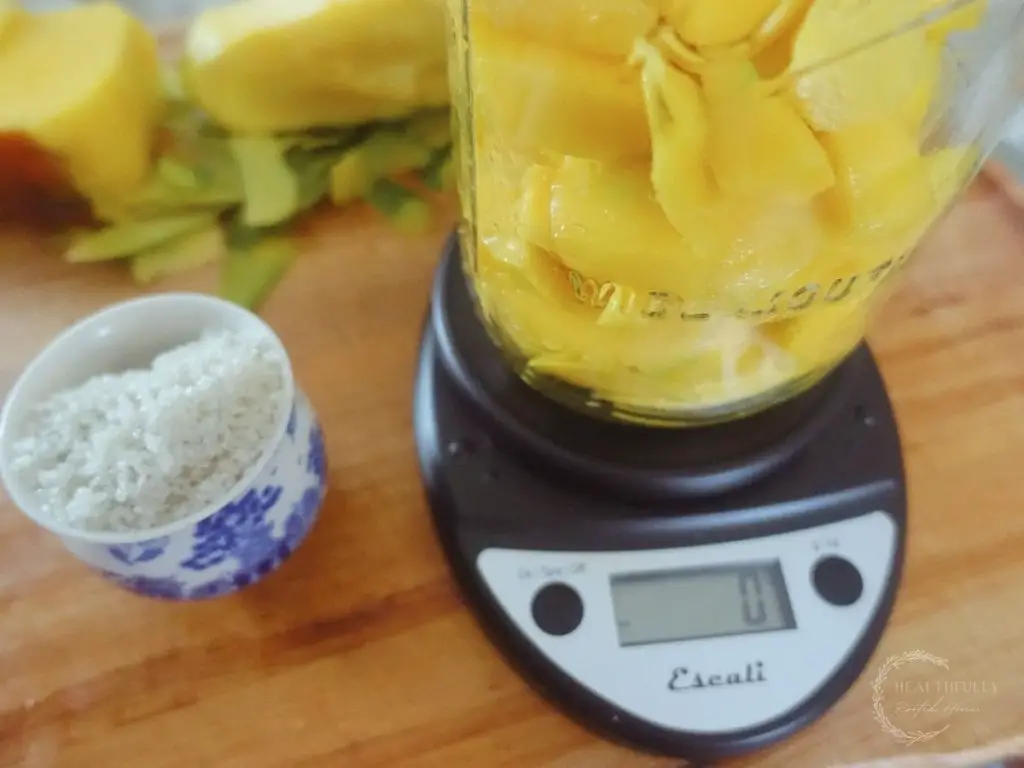 mangos in a mason jar on a kitchen scale which reads zero and sea salt beside it