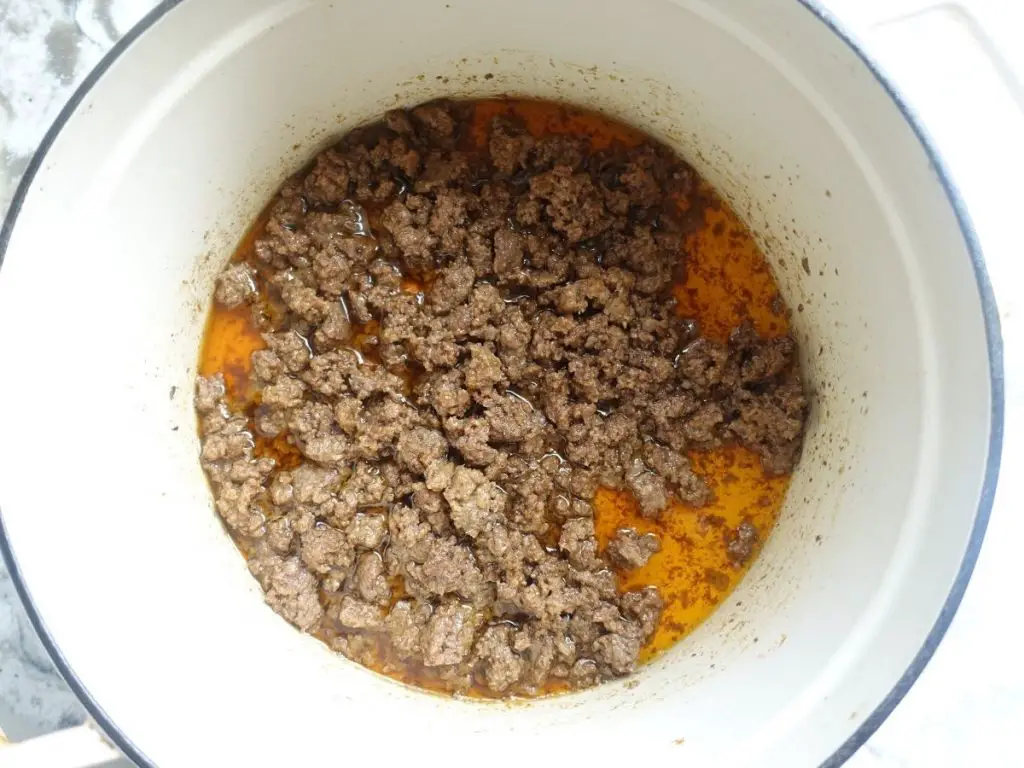 ground beef in a white dutch oven with oil