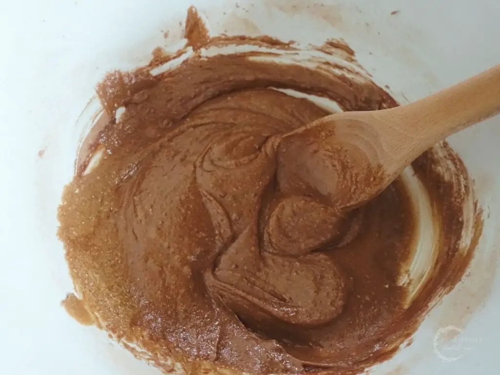 peanut butter bliss ball batter with a wooden spoon