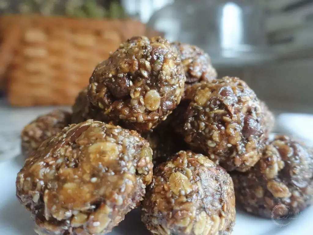peanut butter bliss balls in a pyramid with a basket in the background