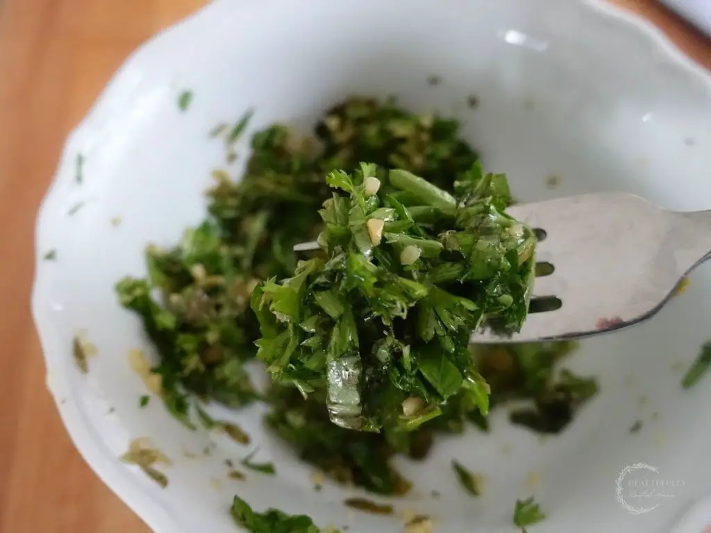 salsa gremolata in a white bowl on top of a fork