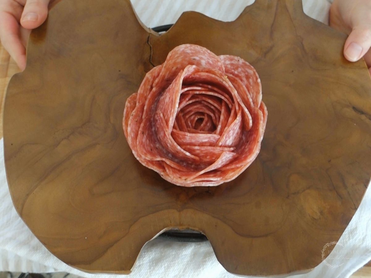 salami rose in the middle of a charcuterie board platter