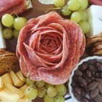 small charcuterie board with all the adornments and a cheese knife inside the brie
