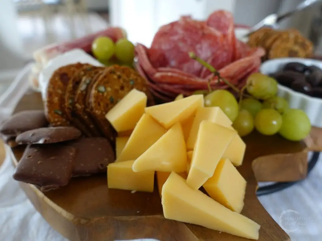 charcuterie board with smoked gouda cheese triangles and chocolate covered graham crackers