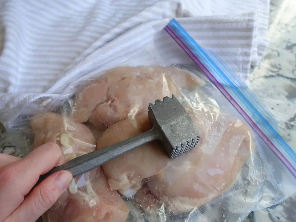 malleting chicken breasts inside of a ziplock bag