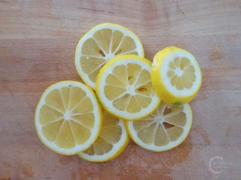sliced and seeded meyer lemons on a wooden cutting board 