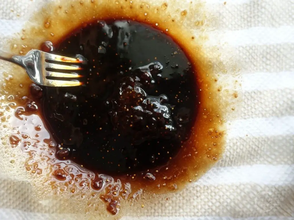 using a fork to whisk fig jam and balsamic vinegar in a glass bowl