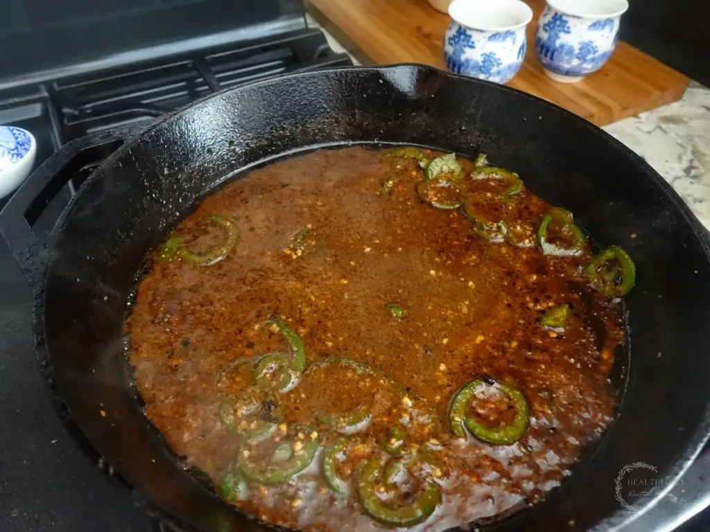 jalapeno honey chicken in a cast iron skillet reducing 