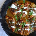honey jalapeno chicken tenders in a cast iron skillet with honey cream sauce and cilantro on top