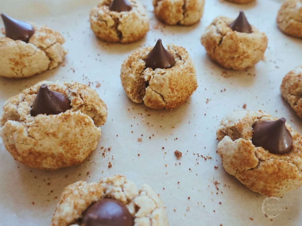 healthy peanut kisses on a baking sheet with hersheys kisses on top