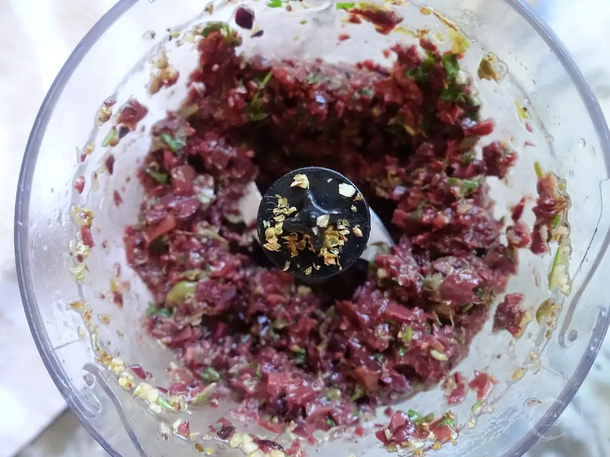 kalamata olive tapenade inside of a food processor ground up