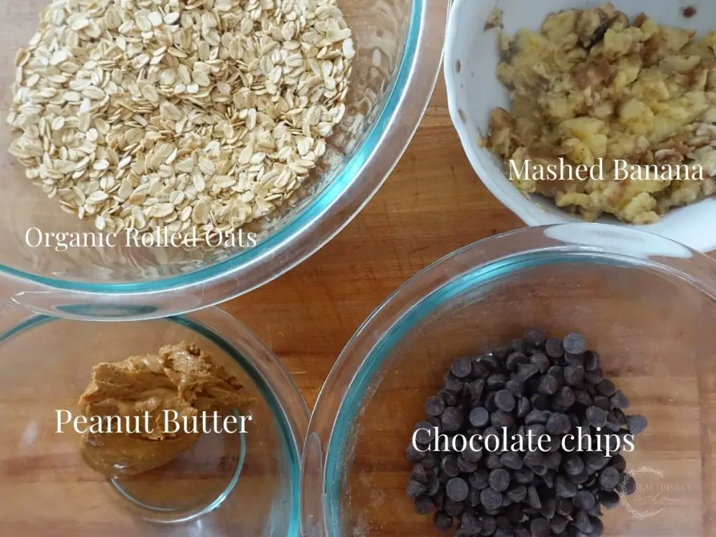 4 ingredients for oatmeal cookies in glass and white bowls with labels saying what they are