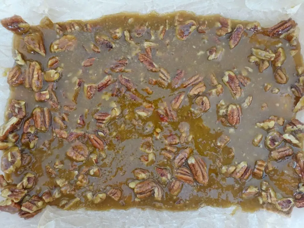 toffee overtop graham crackers in a baking dish line with parchment paper