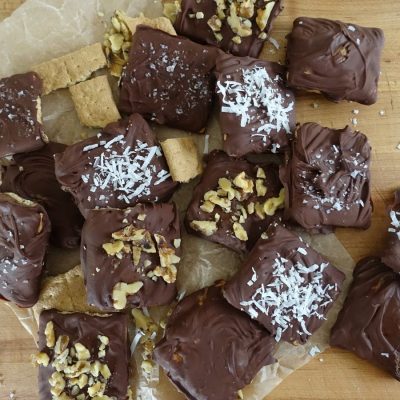 chocolate covered graham crackers on parchment paper with various toppings