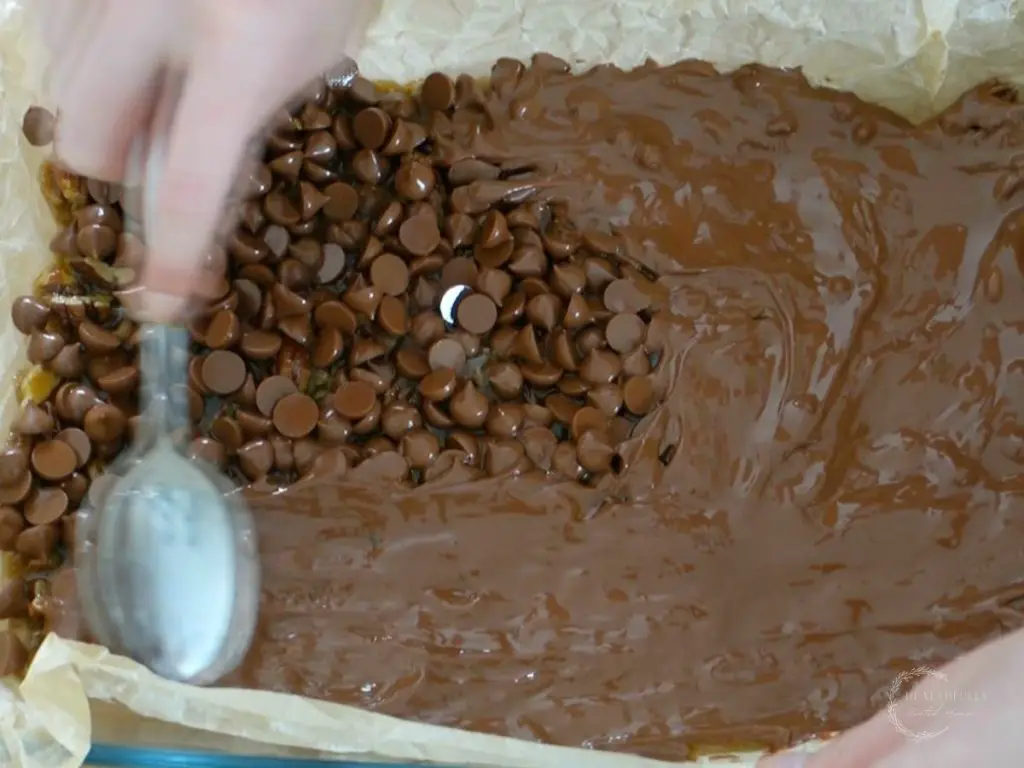 using a spoon to spread chocolate chips 