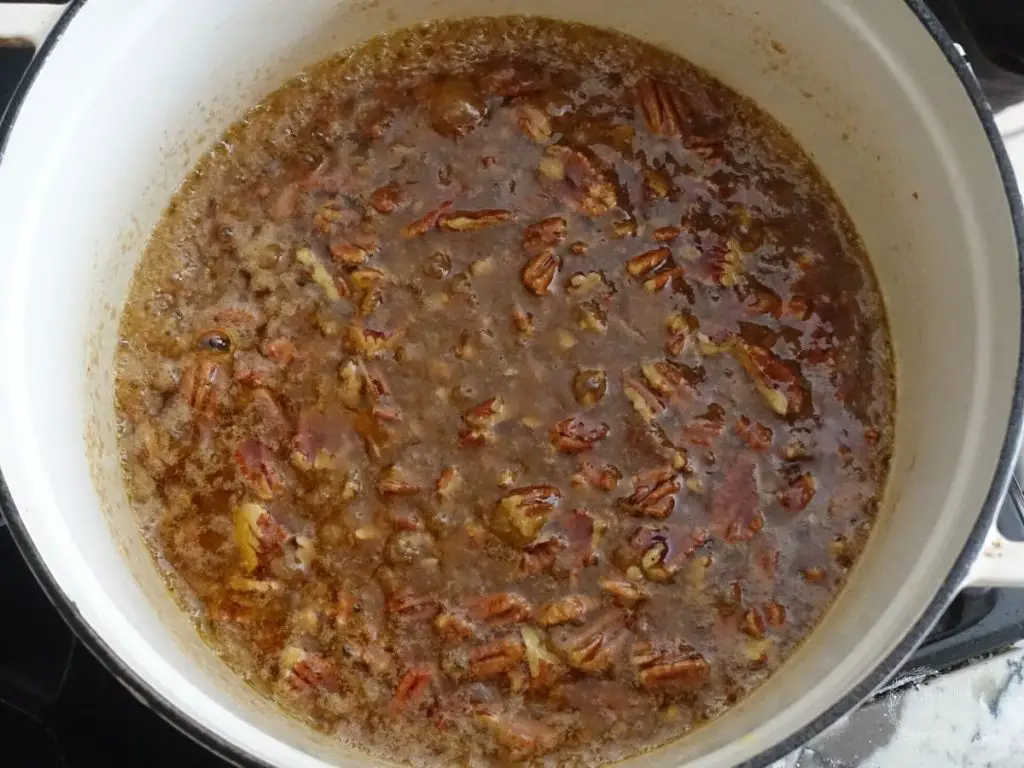 toffee with pecans in a white dutch oven boiling