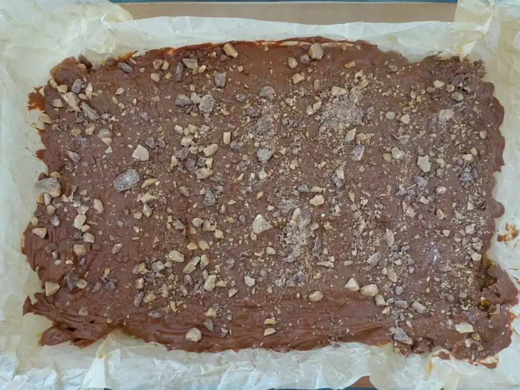 graham cracker crack in a baking dish line with parchment paper and topped with toffee bits