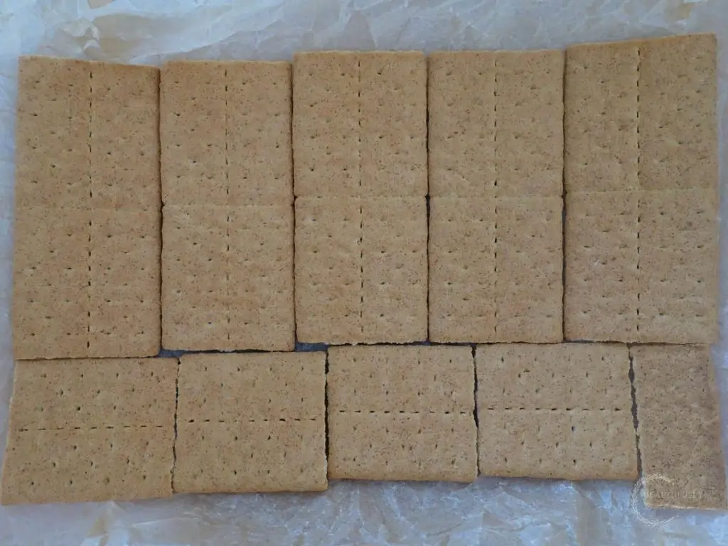 graham crackers arranged in a baking dish line with parchment paper