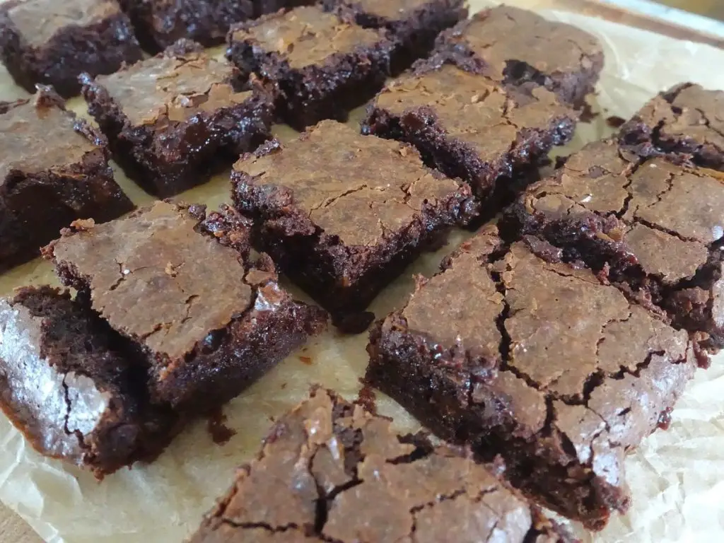 crinkle top brownies coming from a side angle where you can see the flakey top of each brownie