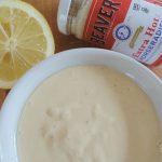 horseradish aioli sauce in a white dish with a lemon on the side and a bottle of beaver prepared horseradish