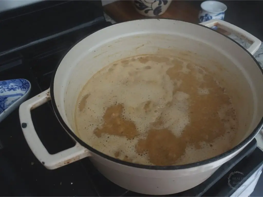 making sweetened condensed milk in a white dutch oven the mixture is at a low boil