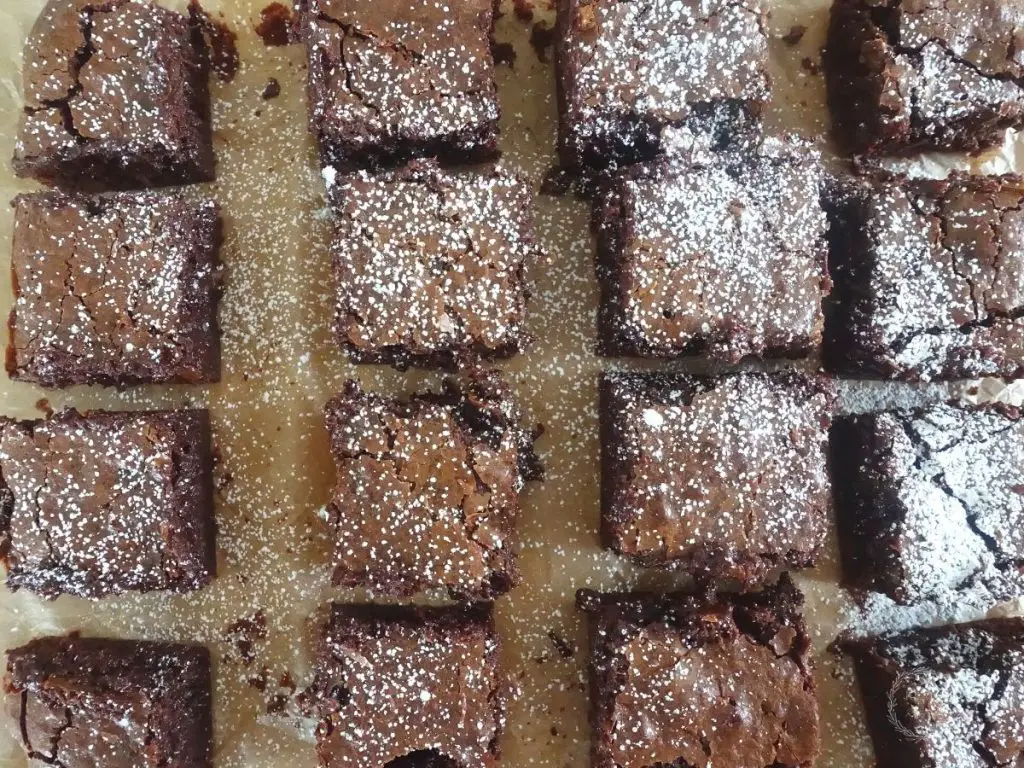crinkle top brownies in rows with powdered sugar dusted on some