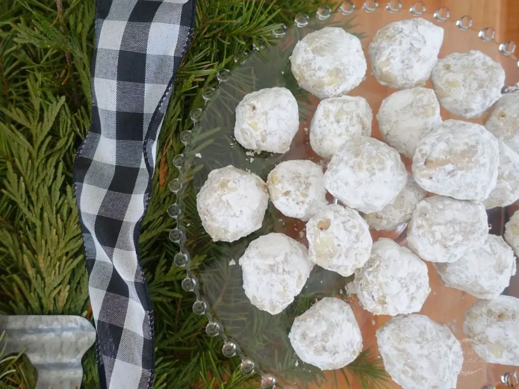 pecan meltaway cookies next to a fir tree with a black and white checkered ribbon