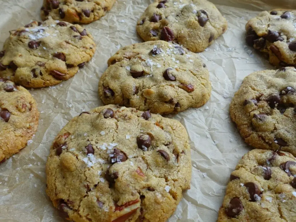 maple chocolate chip cookies on a parchment lined baking sheet in rows