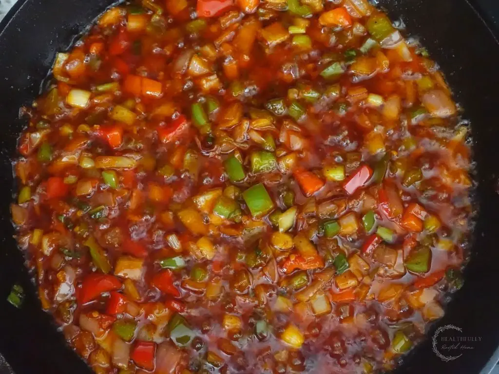 sauteed vegetables mixed with manchurian gravy sauce in a cast iron skillet while bubbling