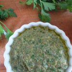 salsa gremolata in a white dish with italian flat leaf parsley and a lemon next to it