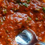 manchurian gravy sauce with a silver spoon scooping some out