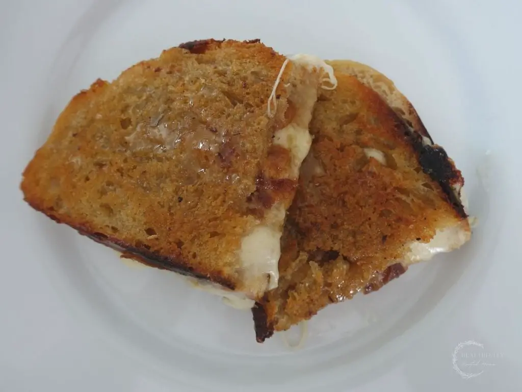 provolone grilled cheese sandwich on a white plate slightly stacked