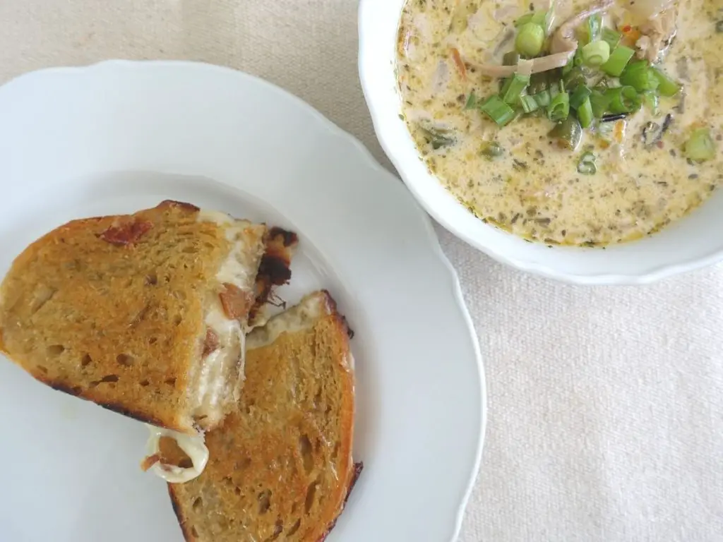 soup and provolone grilled cheese in white bowl and plate
