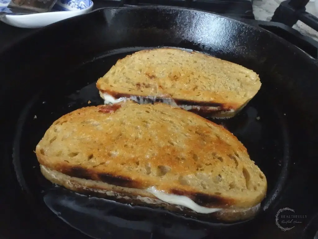provolone grilled cheese sandwiches flipped inside of a cast iron skillet browned on the top